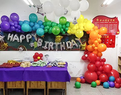 小学生在教室里的生日会彩虹气球布置